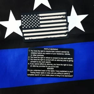 Black custom miranda card with Pirtle warning enscribed on the back in front of a black and blue American flag